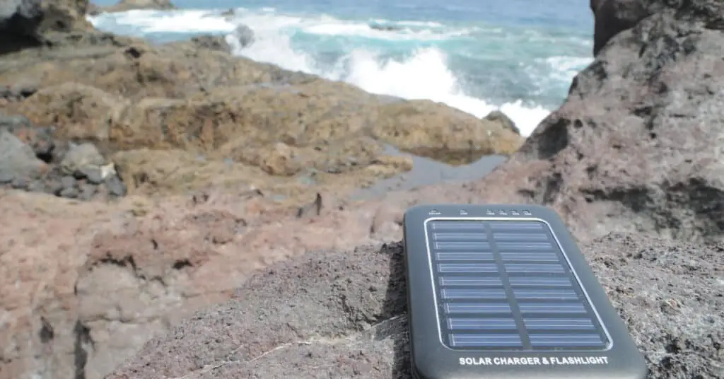 solar charger sitting on rocks with ocean background