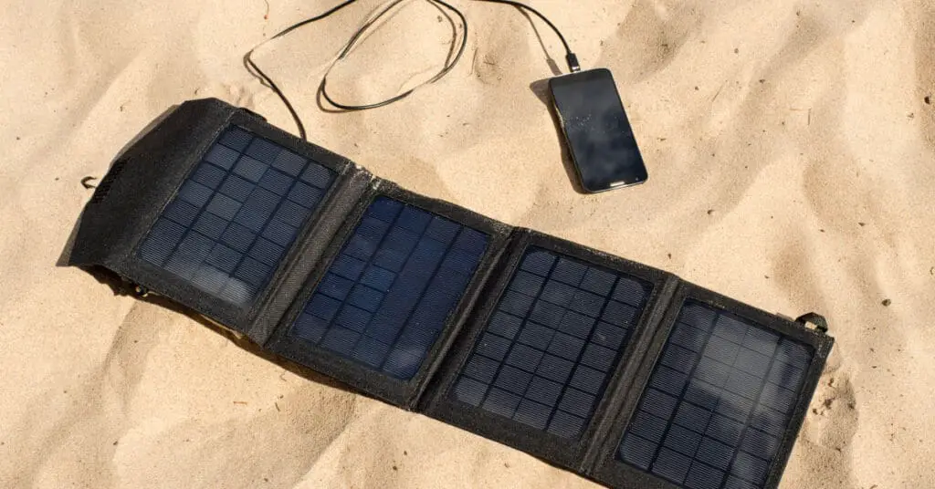 portable solar panel blanket laying on sand connecter to power station